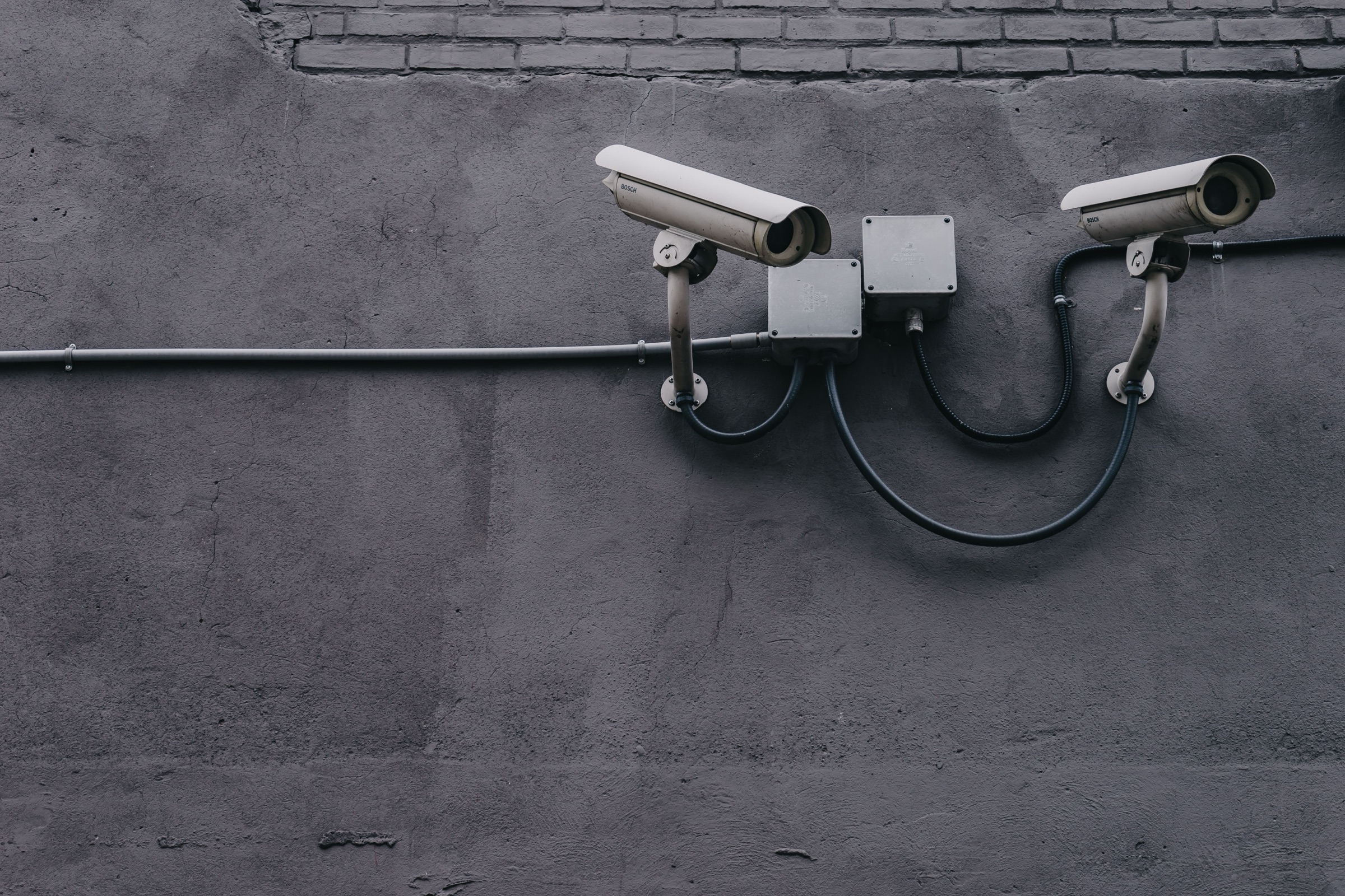 Two security cameras mounted on a concrete wall